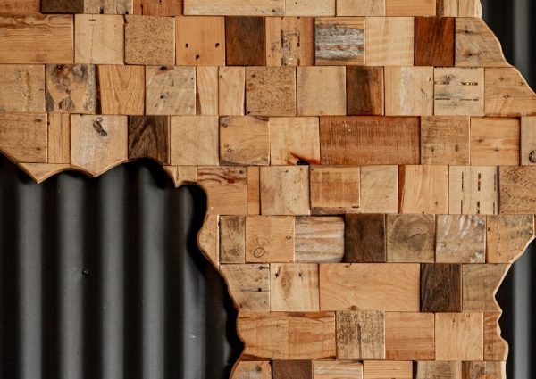 Artistic wooden map of Africa against dark corrugated background.